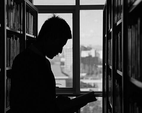 Dark silhouette of a student in a library.