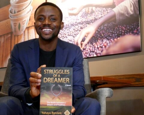 immigrant author Yahaya Baruwa pictured with his book "Struggles of a Dreamer"