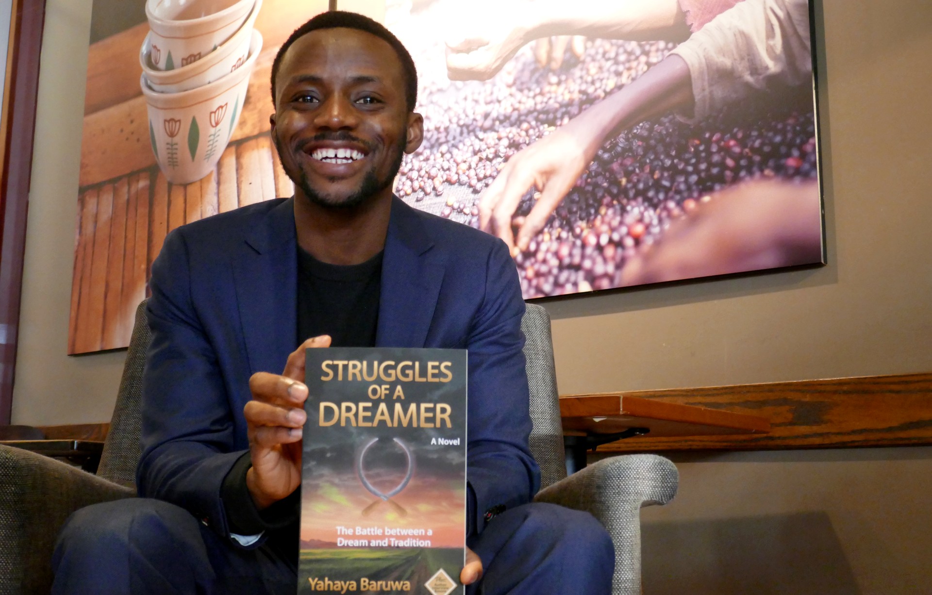 immigrant author Yahaya Baruwa pictured with his book "Struggles of a Dreamer"