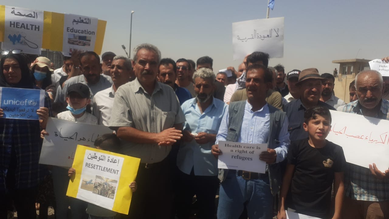 demonstrators protest conditions in a refugee camp.