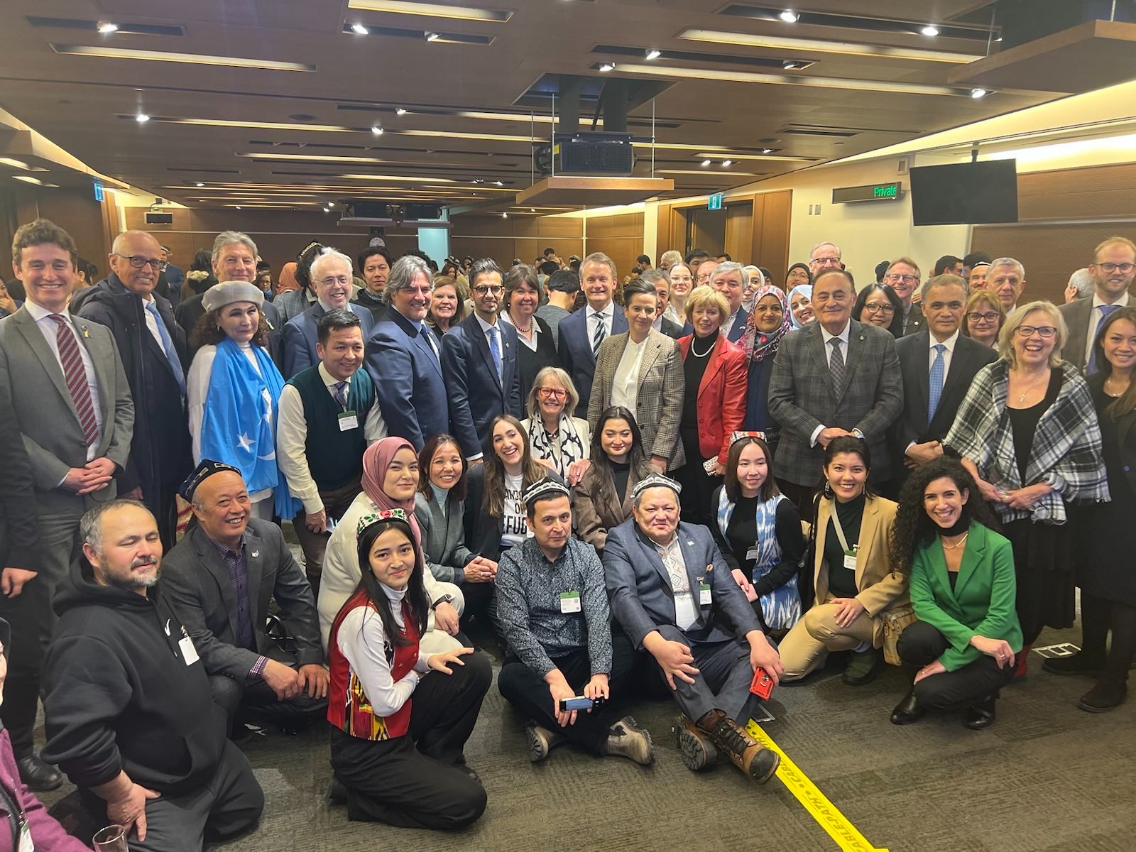 Uyghur community pose with MPs after the motion passed