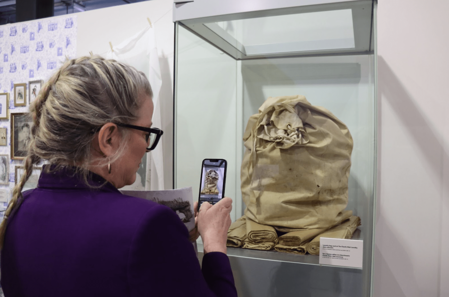 A visitor takes a photo of the laundry bag and brown paper that JJ Lee found in her old attic