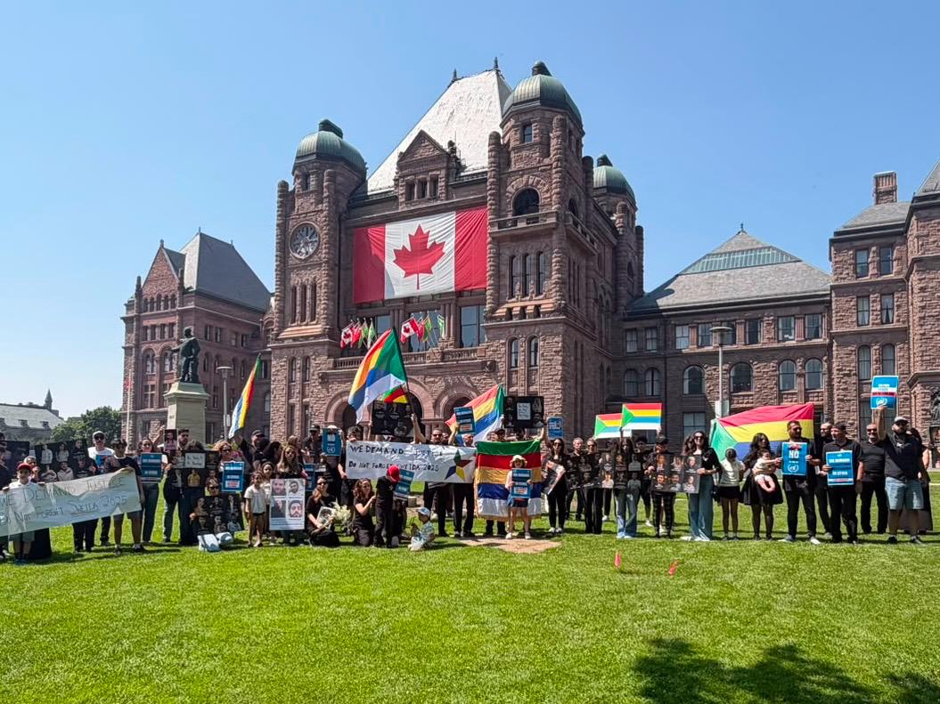 Druze community members hold flags, signs and photographs during a rally outside the Ontario legislature at Queen’s Park in Toronto.